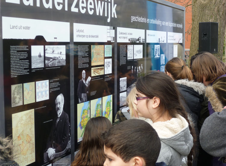 Schoolkinderen uit de Zuiderzeewijk bekijken het zojuist onthulde informatiebord